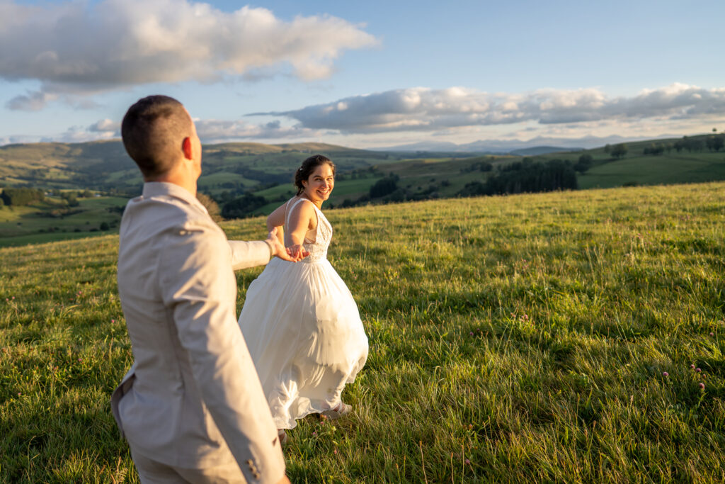 Le couple cours dans les champs dans le massif du Sancy